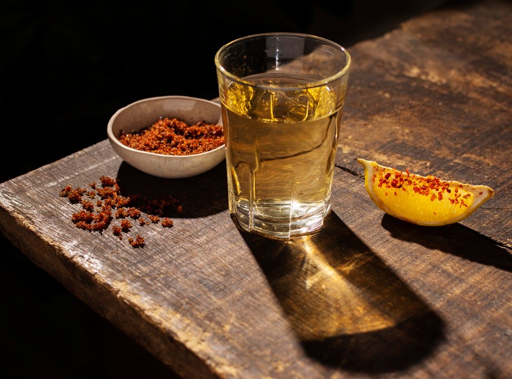 Mezcal reposado servido en tequilero acompañado de sal de gusano